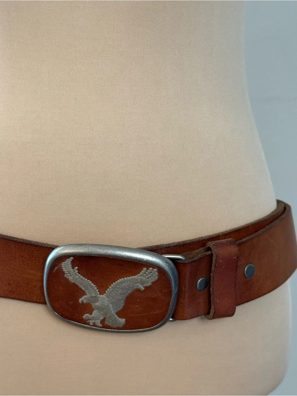 Eagle embroidered bold buckle on a light brown leather belt 44”